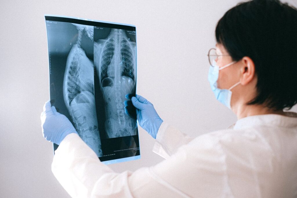 pexels photo 4226257 Medical professional in mask and gloves examining a chest X-ray indoors.